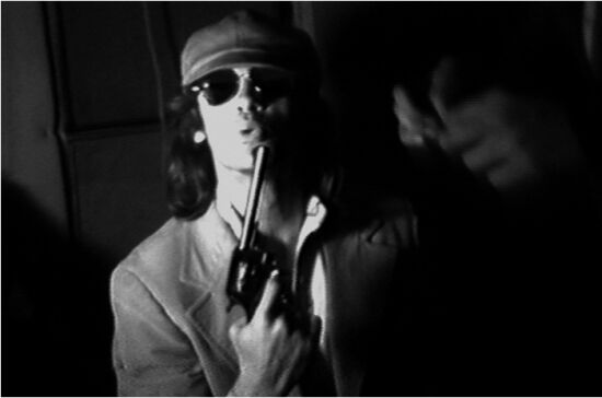 man with sunglasses and hat holding a gun