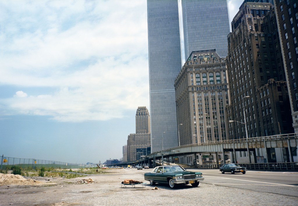 man sleeping beside car near the Twin Towers